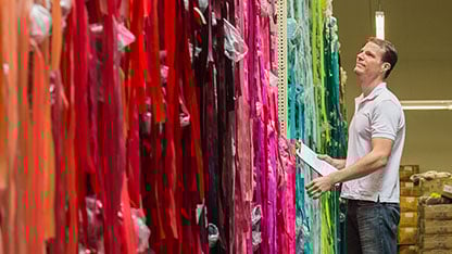 roupa colorida dobrada na prateleira de uma loja