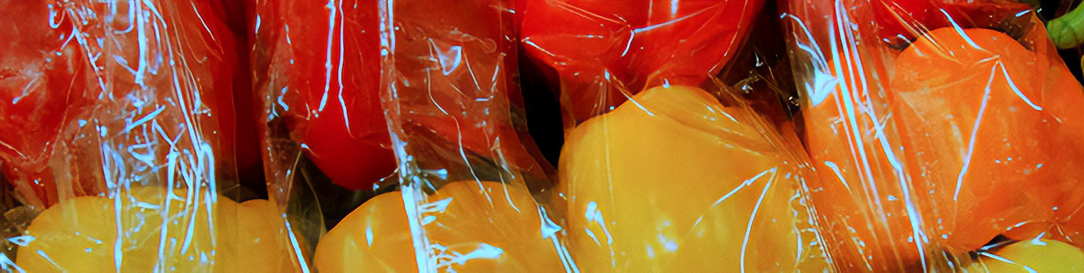 Pimentos vermelhos e amarelos embrulhados em película aderente