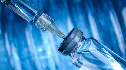 A syringe inserted into a glass vial highlighting the need for studies to identify particulates and foreign particulate matter in injectable drugs